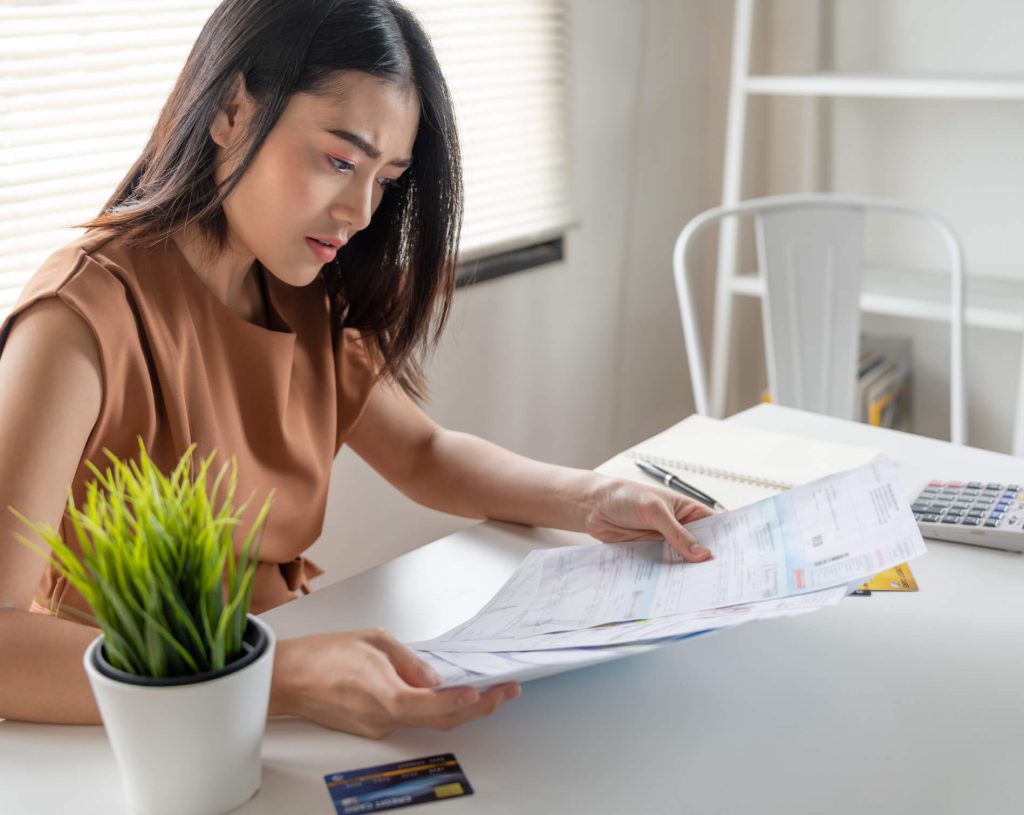 woman frowning at credit card paperwork