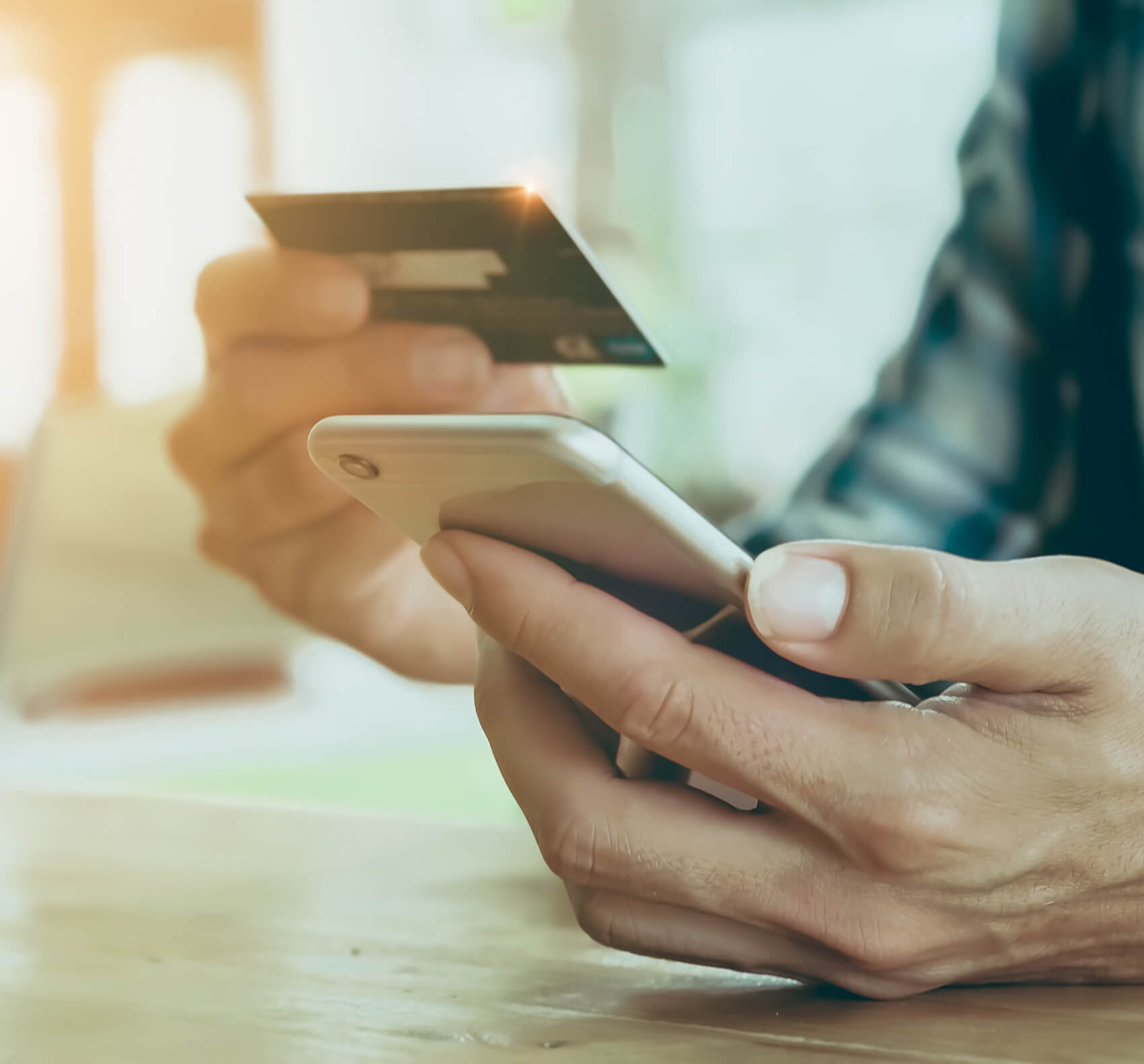 person holding credit card and typing on phone