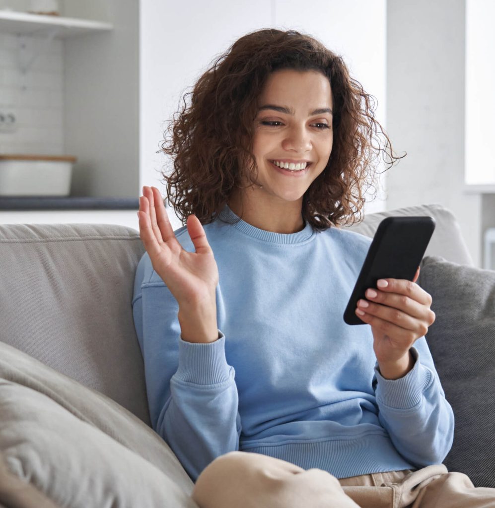 woman smiling and typing on cell phone