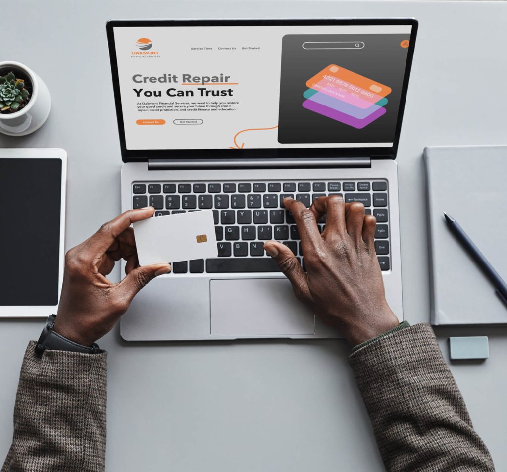 man's hands holding credit card and typing on computer